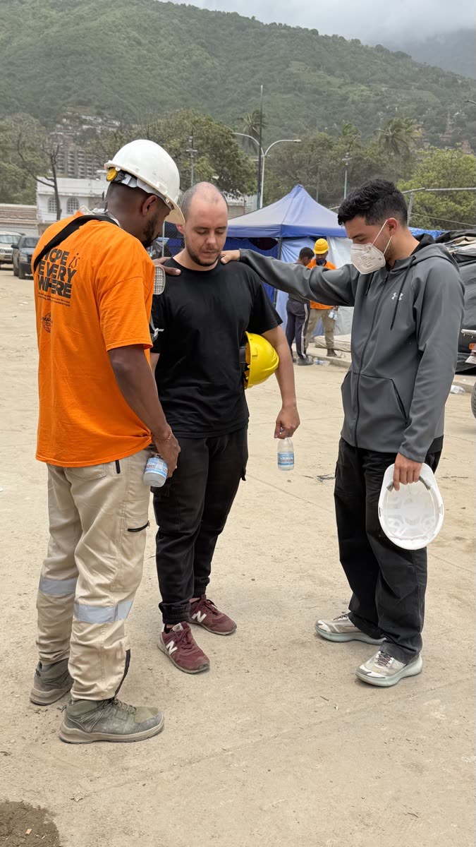 Voluntários orando juntos durante a resposta à emergência