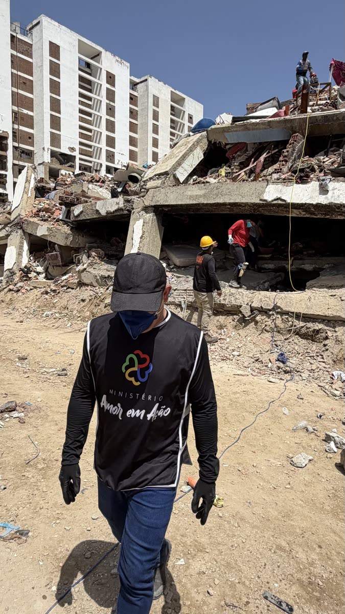 Voluntário caminhando entre edifícios destruídos pelo terremoto